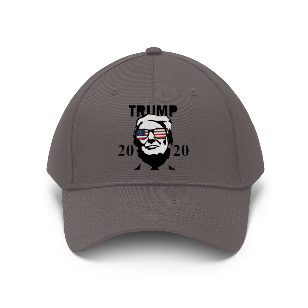 Trump 2020 With US Flag Glasses Twill Cap featuring a bold graphic design of Trump wearing US flag glasses.