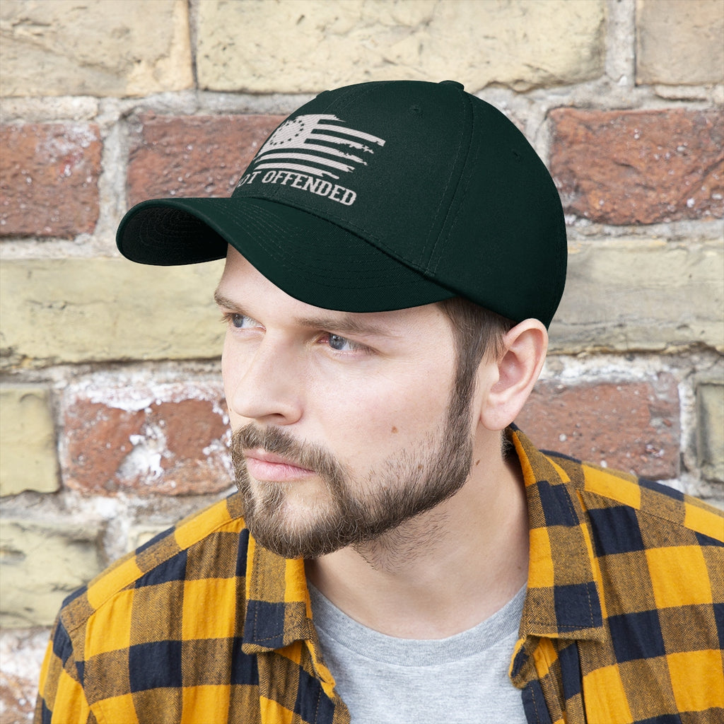 Embroidered Not Offended Adjustable Twill Cap showcased on a man against a brick wall background.