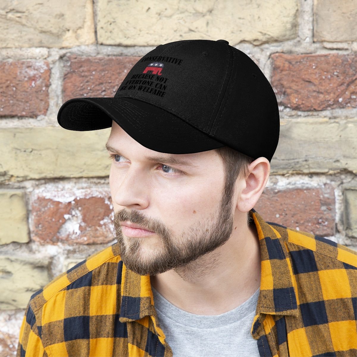 Man wearing a Conservative Values Twill Cap Design against a brick wall, showcasing bold statement and style.