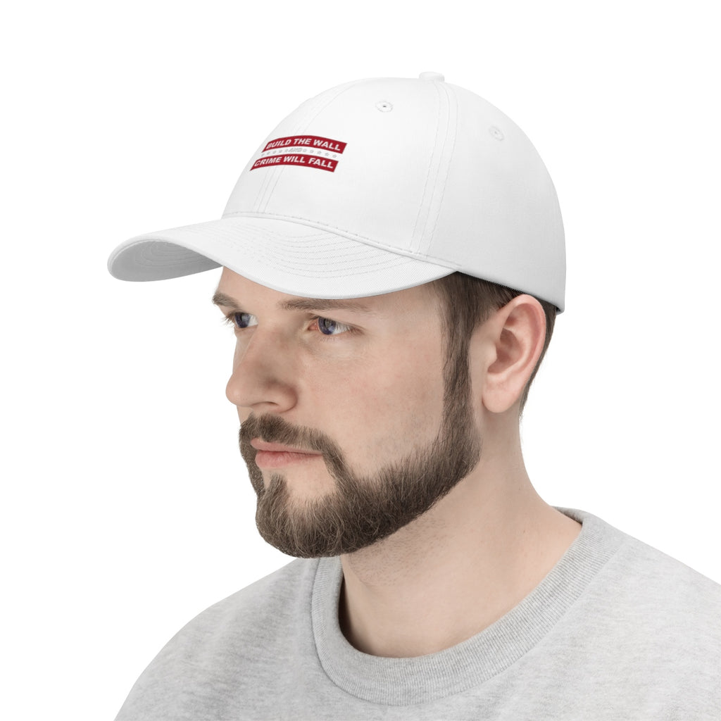 Build The Wall And Crime Will Fall Twill Cap worn by a man, featuring political slogans on a white cap.