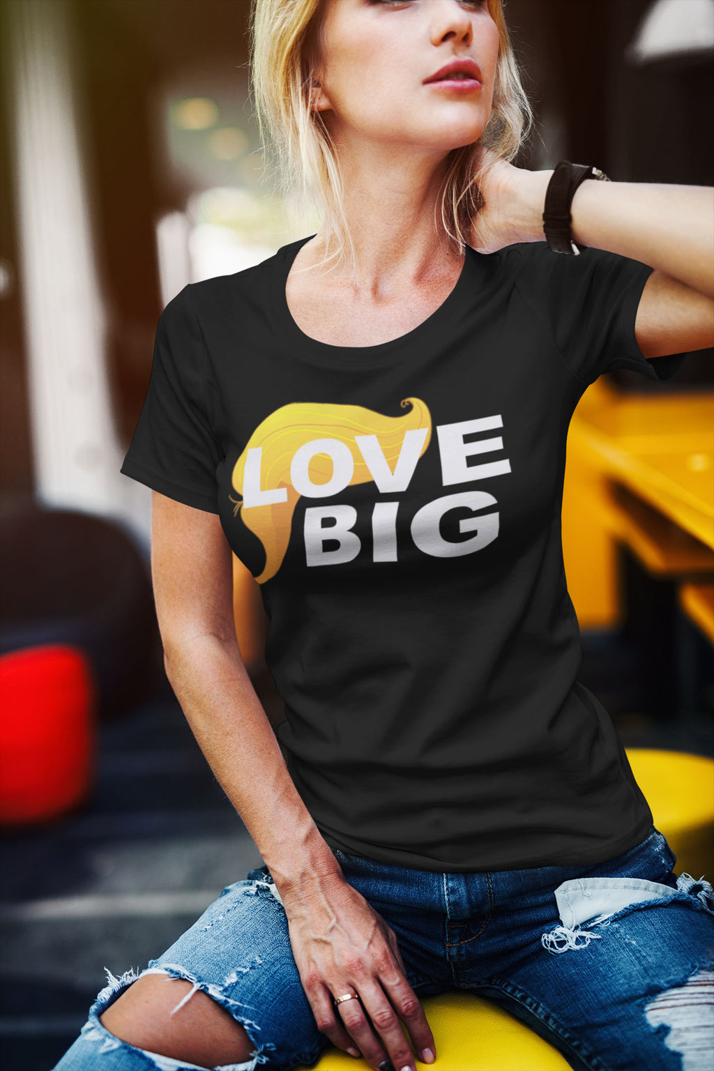 Woman wearing Love Big With Hair 2 Trump Humor Statement Tee in vibrant setting
