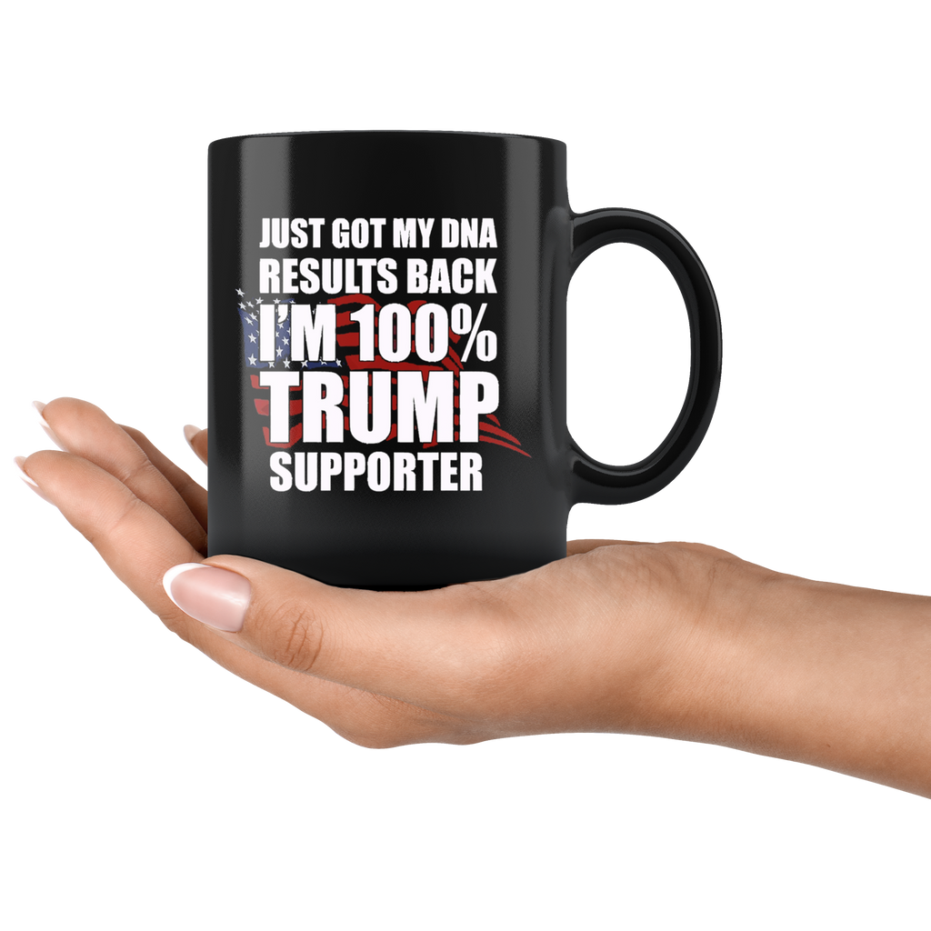 Black mug with text 'Just Got DNA Results I Am 100 Percent Trump Supporter' held in hand