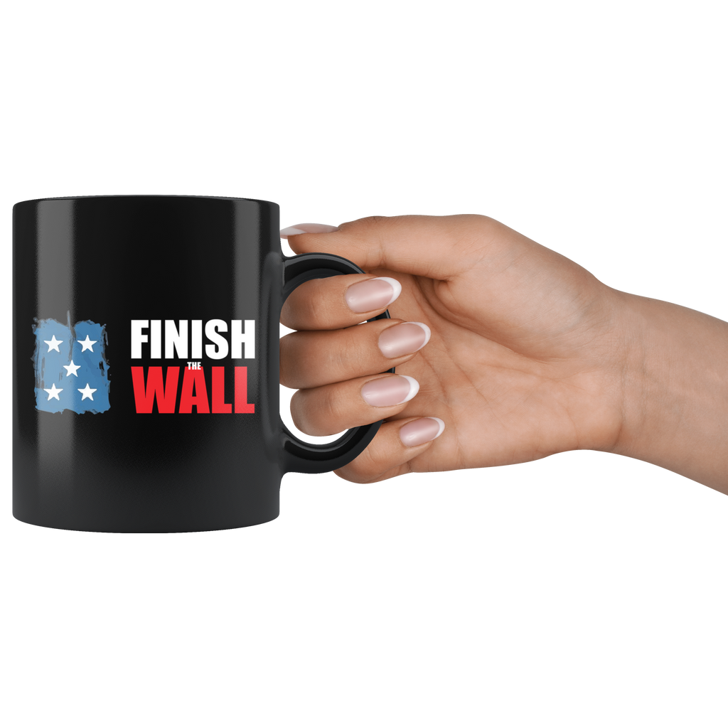 Finish The Wall Ceramic Coffee Mug held in a hand, high quality 11oz black ceramic with vibrant design, dishwasher and microwave safe