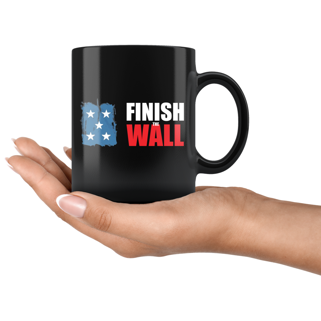 Hand holding a Finish The Wall Ceramic Coffee Mug with high gloss black finish, featuring vibrant design, perfect for hot and cold beverages.